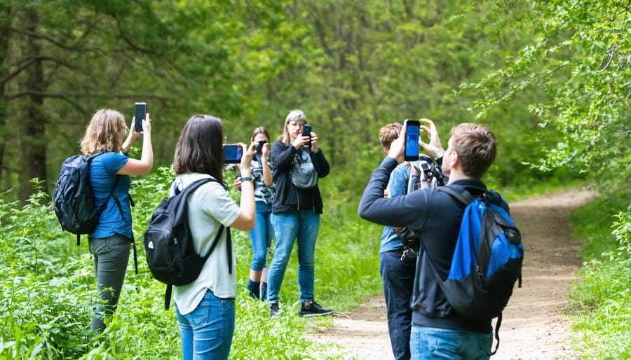 Park visitors of various ages using mobile devices to participate in citizen science activities