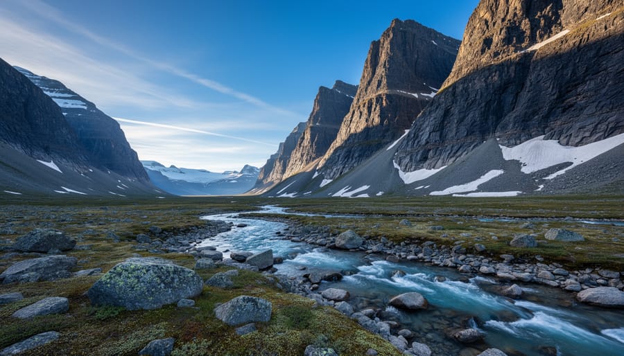 Hikers in front of dramatic granite peaks and tundra landscape in Auyuittuq National Park